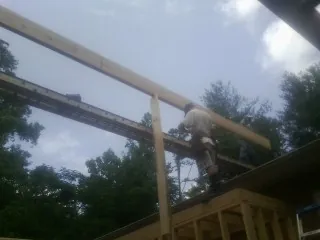 Carpenter setting a ridge beam over a new addition frame — Ice Dam Removal by Roofing Brothers in Moroni