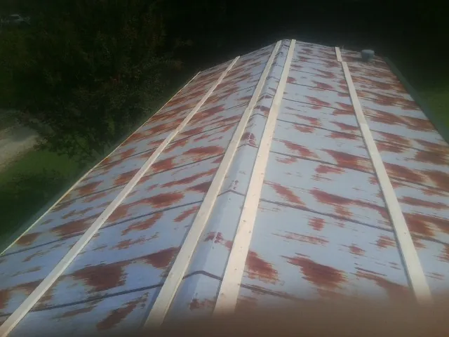 Rusted metal roof panels with new wood purlins before replacement — Storm Damage Roof Repair in Moroni by Roofing Brothers
