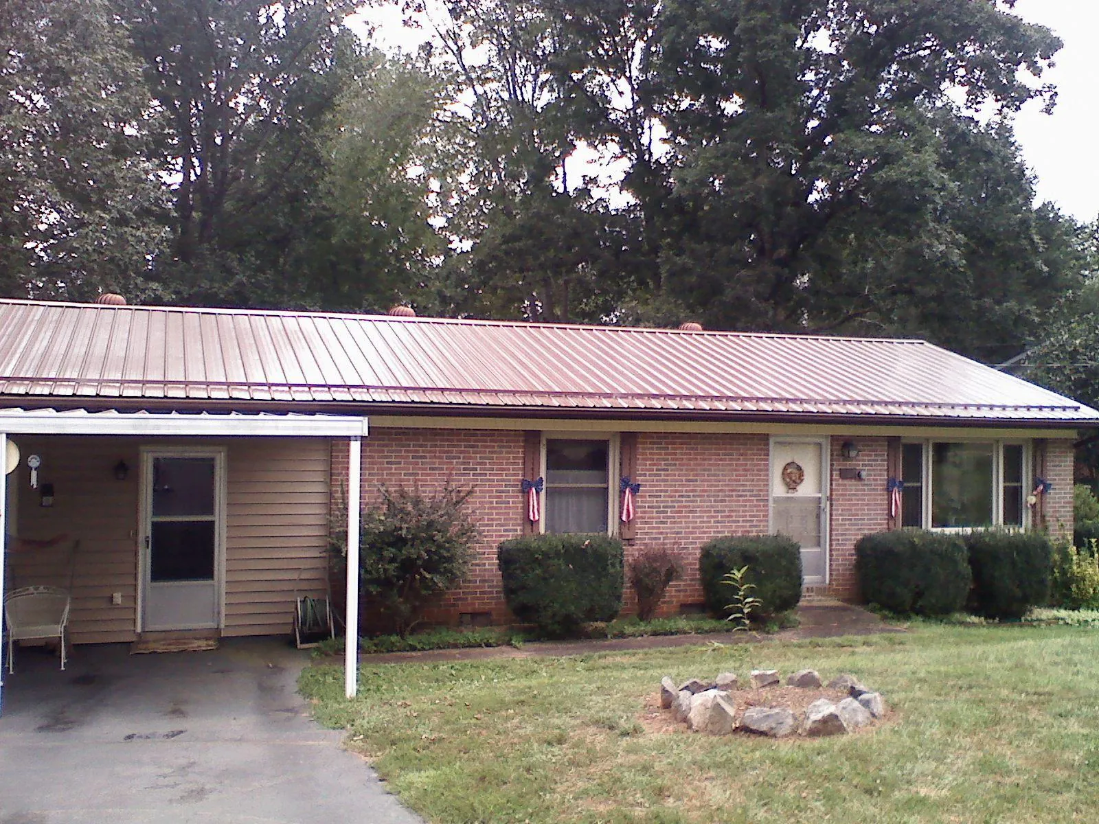 Bronze metal roof and carport on a brick ranch home — Roof Repair work by our crew in Moroni